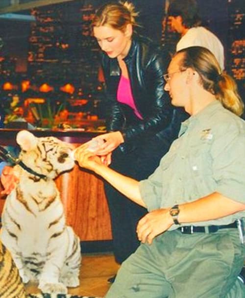 Kate Winslet feeding milk to a tiger cub. 